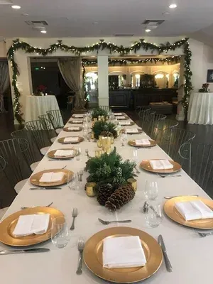 Decorated banquet table set for a holiday gathering in a festively lit room