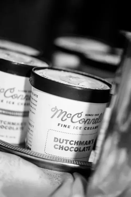 Black-and-white close-up of McConnell’s Fine Ice Cream “Dutchman Chocolate” pint containers.