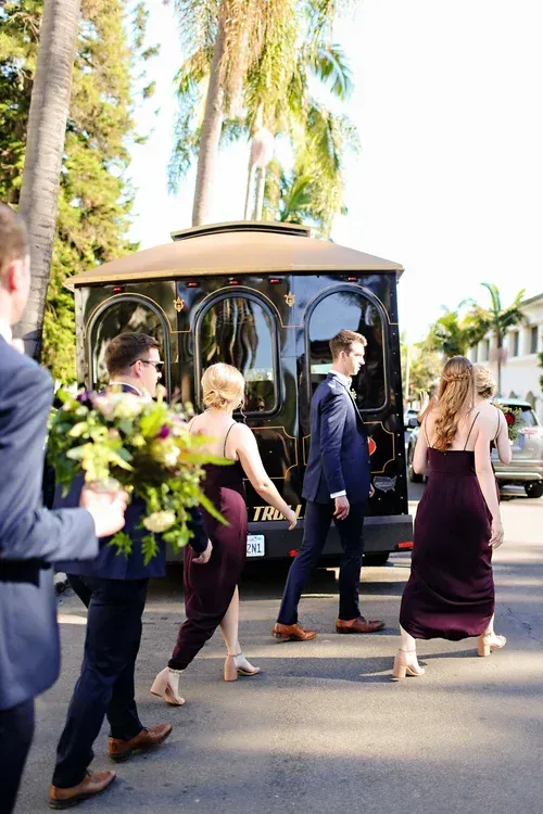 Guests walking past a gazebo at an outdoor wedding in a sunny courtyard