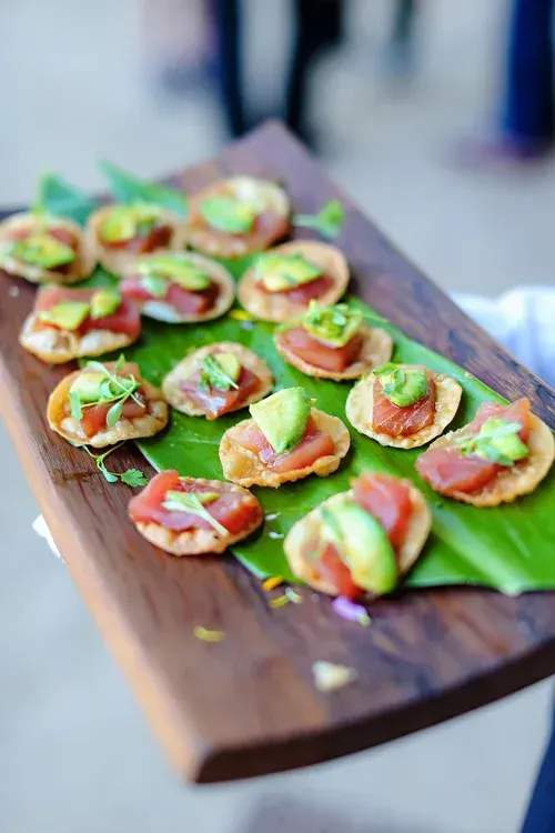 Bruschetta appetizers on a wooden board with basil and tomato garnish