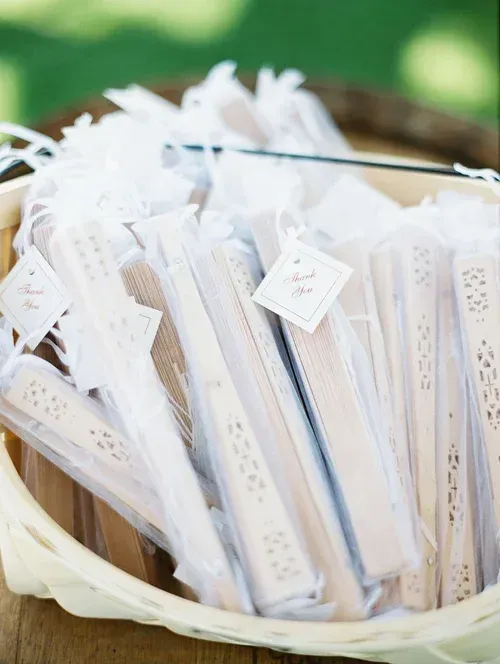 Basket filled with white paper tags or bookmarks tied with ribbon