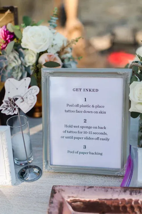 Framed wedding sign on table with flowers, candle, and greenery centerpiece