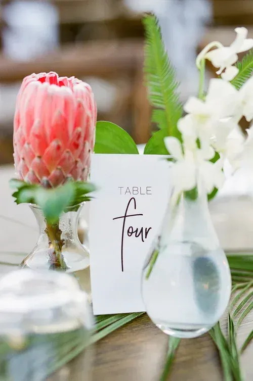 Table setting with pink flower centerpiece, white vase, and 