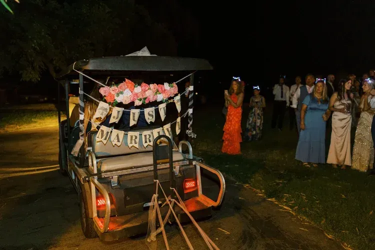 Decorated rickshaw at night with people gathered beside it outdoors
