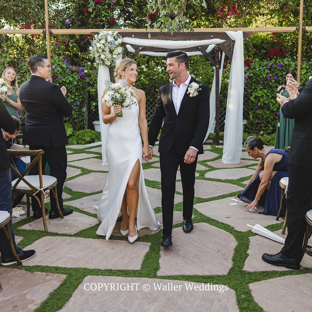 Bride and groom walking down aisle in an outdoor garden wedding ceremony