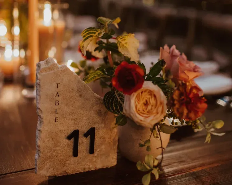 Table number 11 beside a small floral arrangement on a warmly lit table