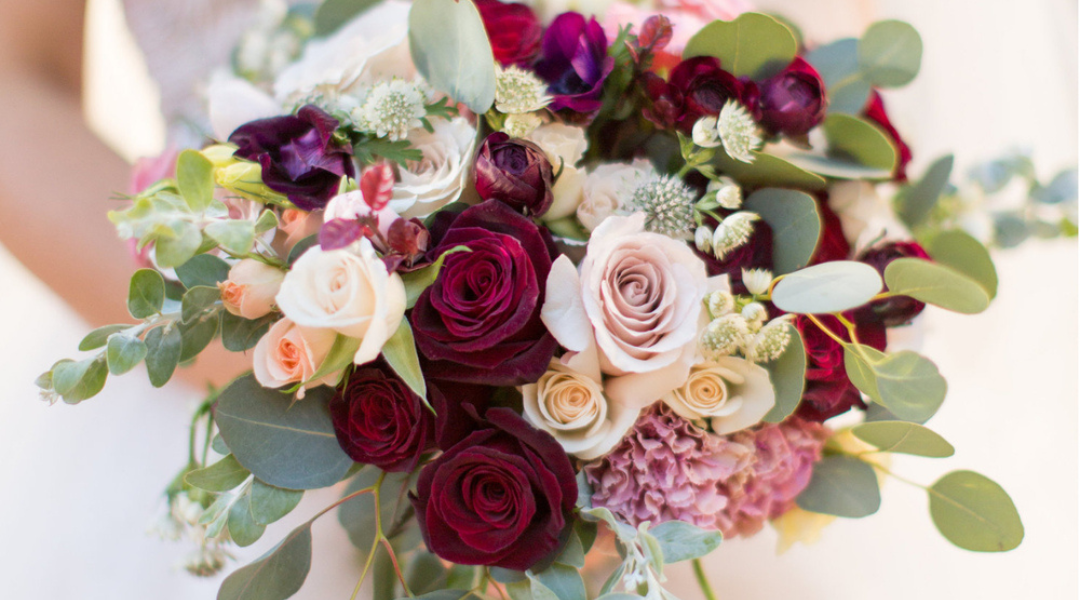 Bouquet of burgundy, blush, and white roses with eucalyptus greenery