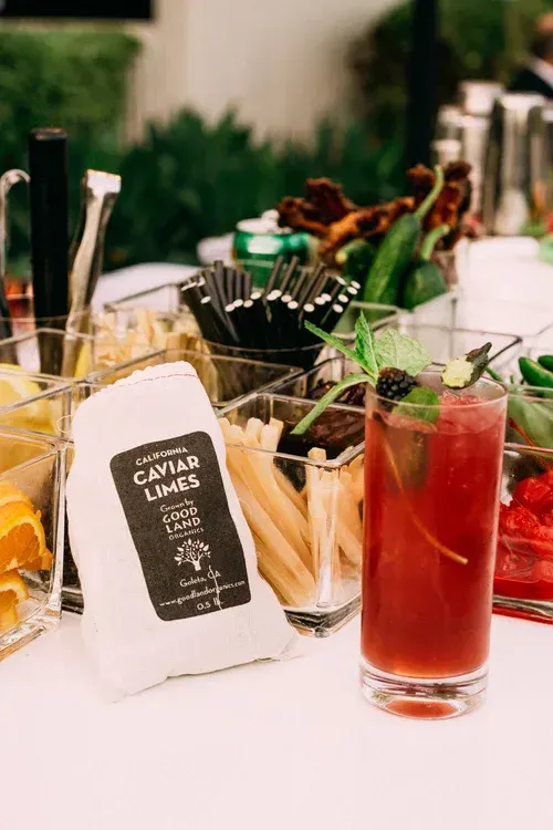 Fruit and snack buffet with a red drink at a catered event table