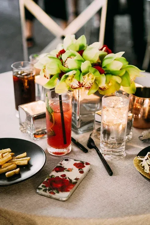 Floral centerpiece with candles and drinks on a decorated dinner table