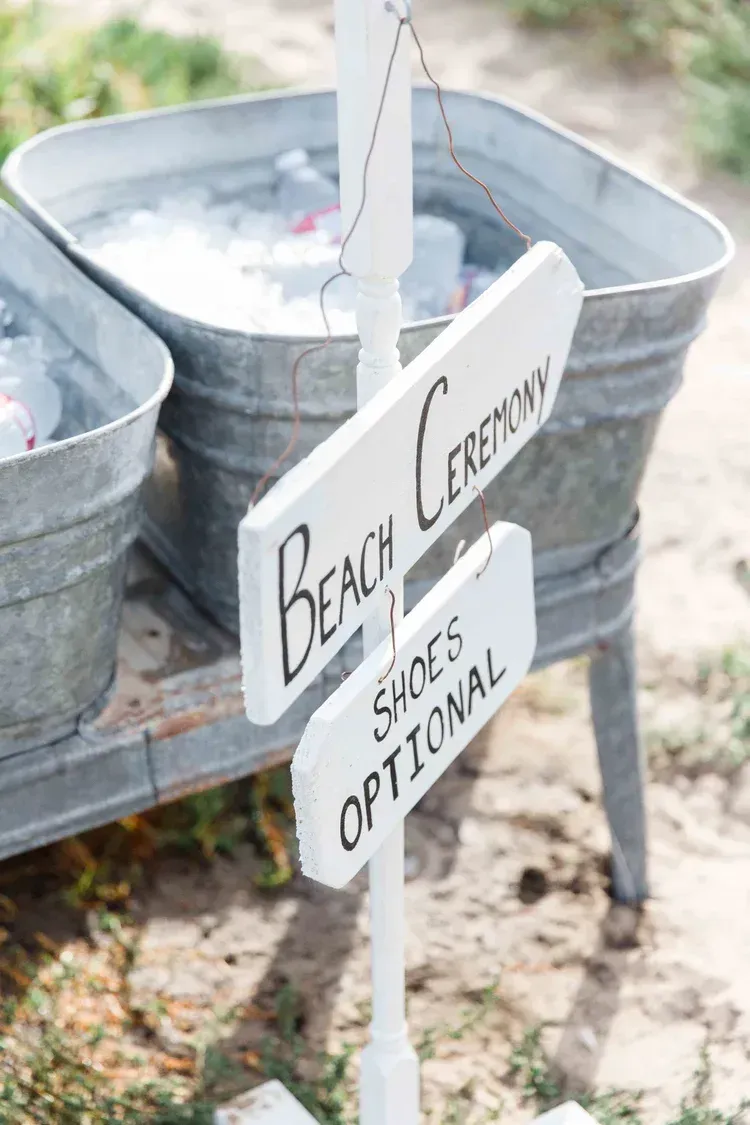 Beach Center sign beside metal tubs and a small optional shades sign outdoors