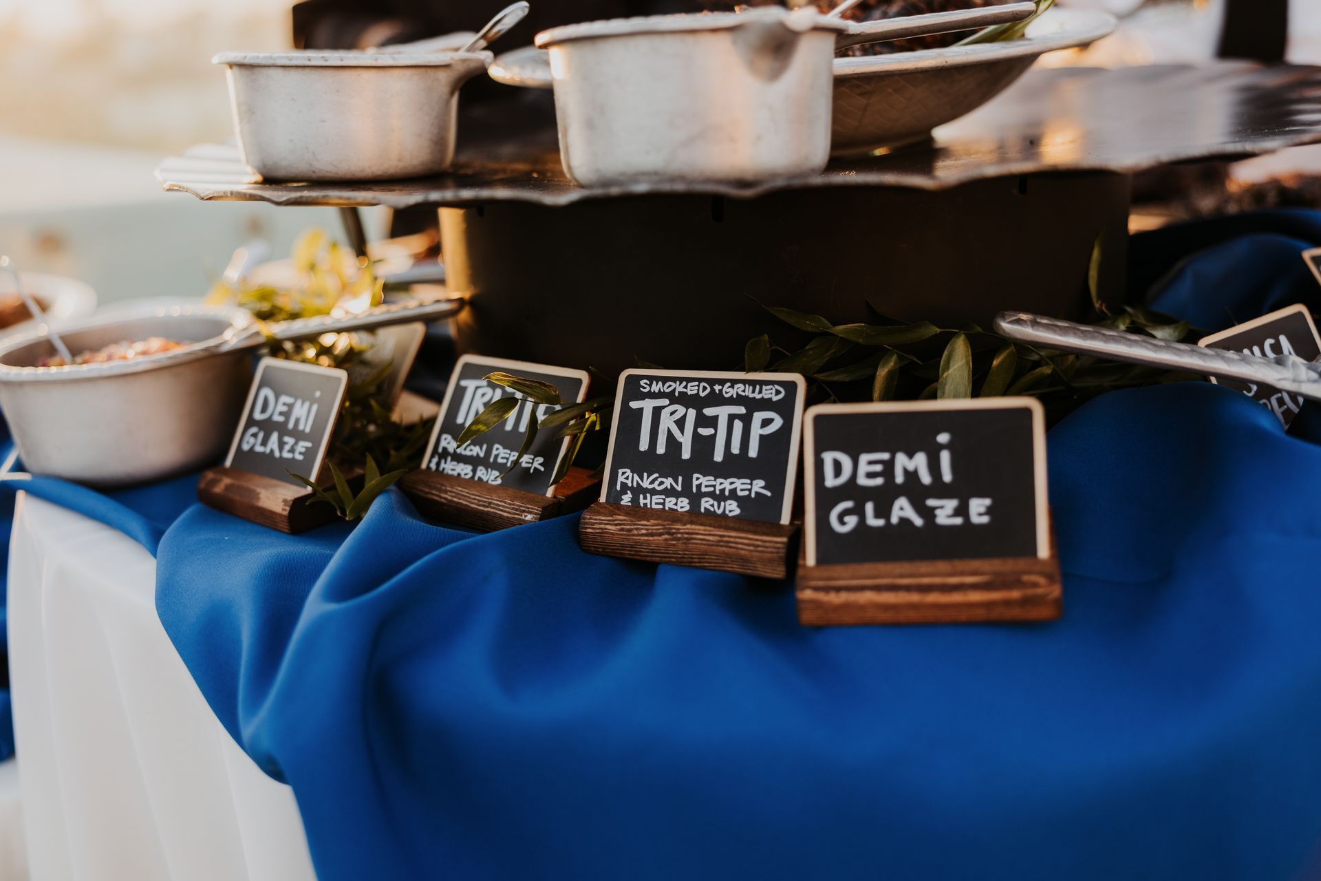 Small glazed dessert samples with handwritten flavor labels on a blue tablecloth