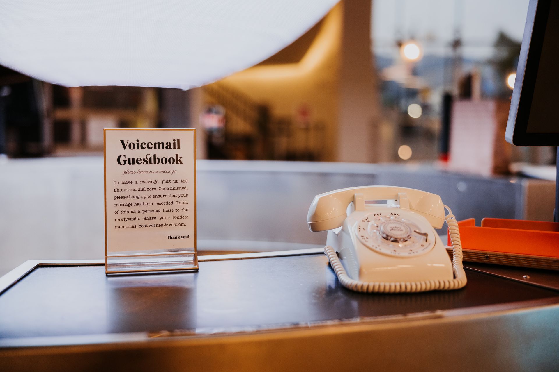 Welcome sign beside a beige rotary phone on a counter in a warm, softly lit room