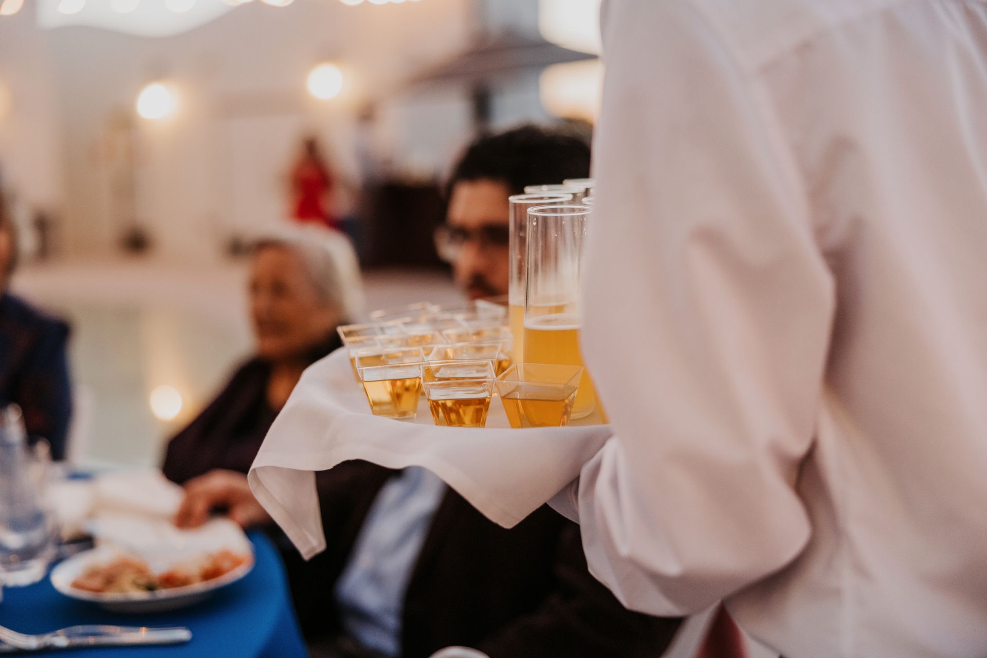Waiter carrying tray of drinks at a formal indoor event