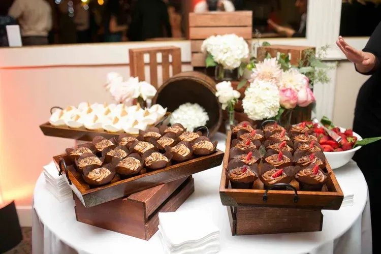 Dessert buffet with assorted chocolate pastries on a round table at a decorated event