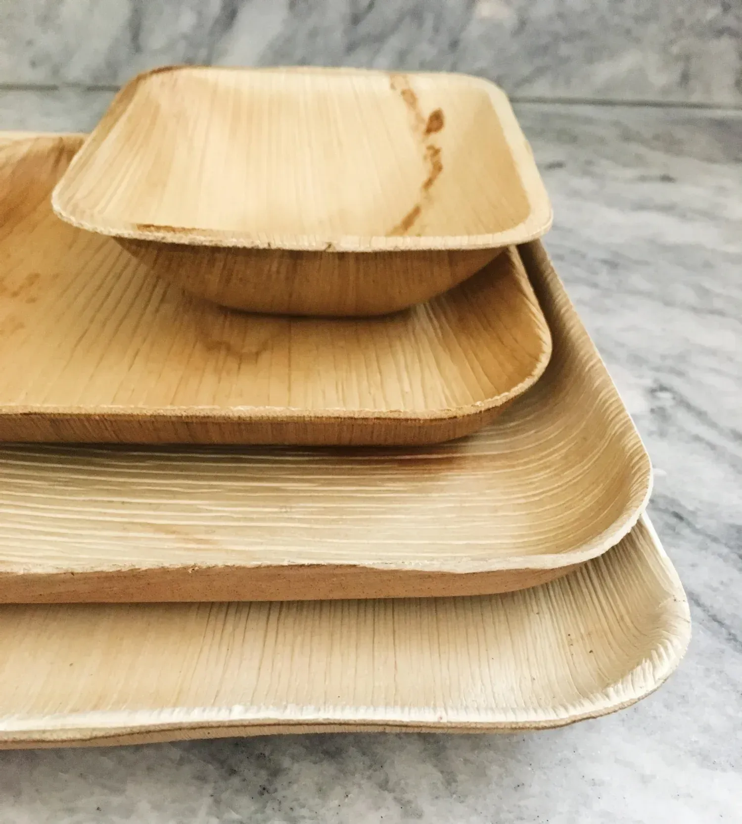 Stacked natural bamboo plates on a marble surface