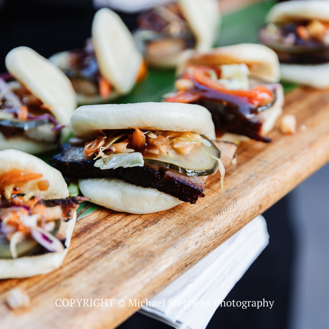Small stuffed sandwiches with sauce on a wooden serving board