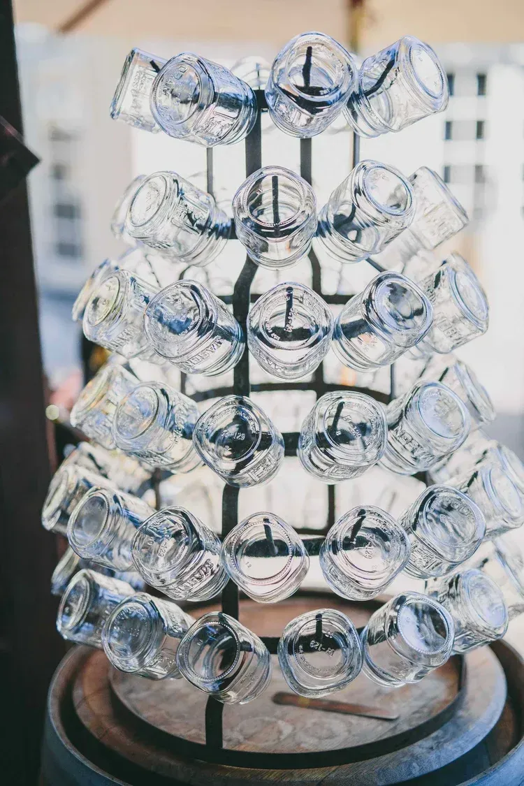 Stacked clear crystal glasses displayed on a tiered stand outdoors