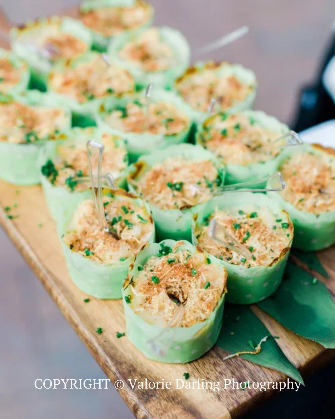 Green cups of savory appetizers topped with herbed crumbs on a wooden serving board