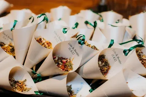 White paper cones filled with colorful dried flowers, arranged in a basket or tray