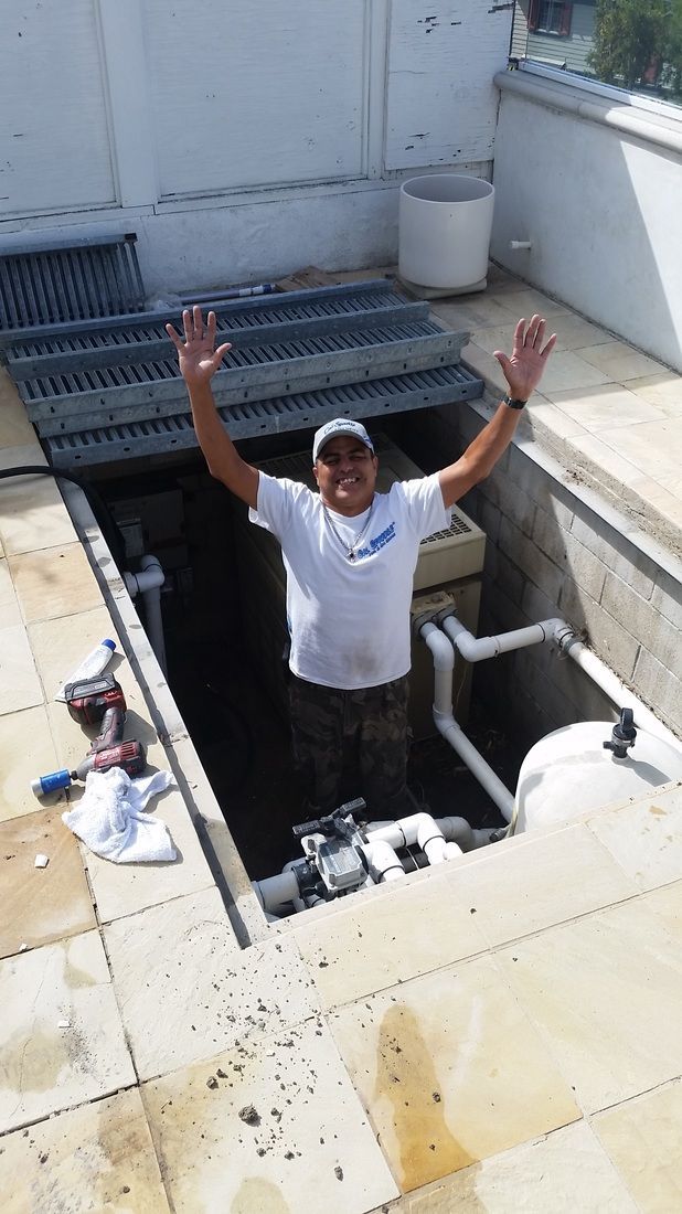 A man is standing in a hole with his arms in the air.