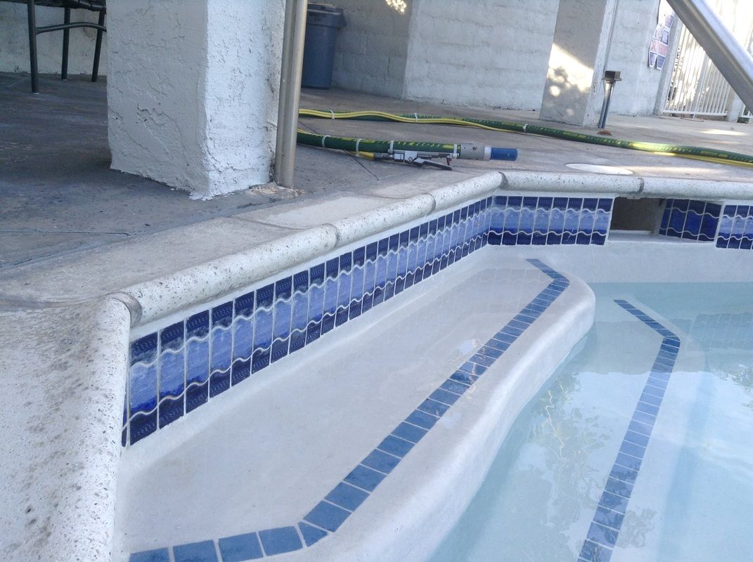 A swimming pool with blue tiles and white steps