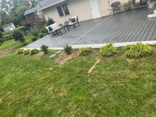 A Backyard With A Deck And A House In The Background - Perry Hall, MD - Oakwood Landscaping LLC