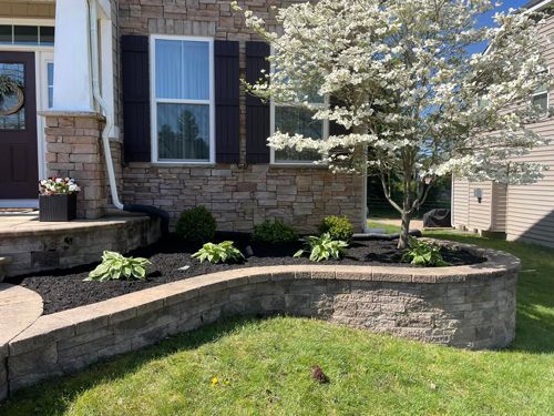 A House With A Brick Wall And A Tree In Front Of It - Perry Hall, MD - Oakwood Landscaping LLC