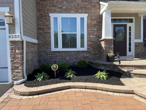 The Front Of A Brick House With A Brick Walkway Leading To The Front Door - Perry Hall, MD - Oakwood Landscaping LLC
