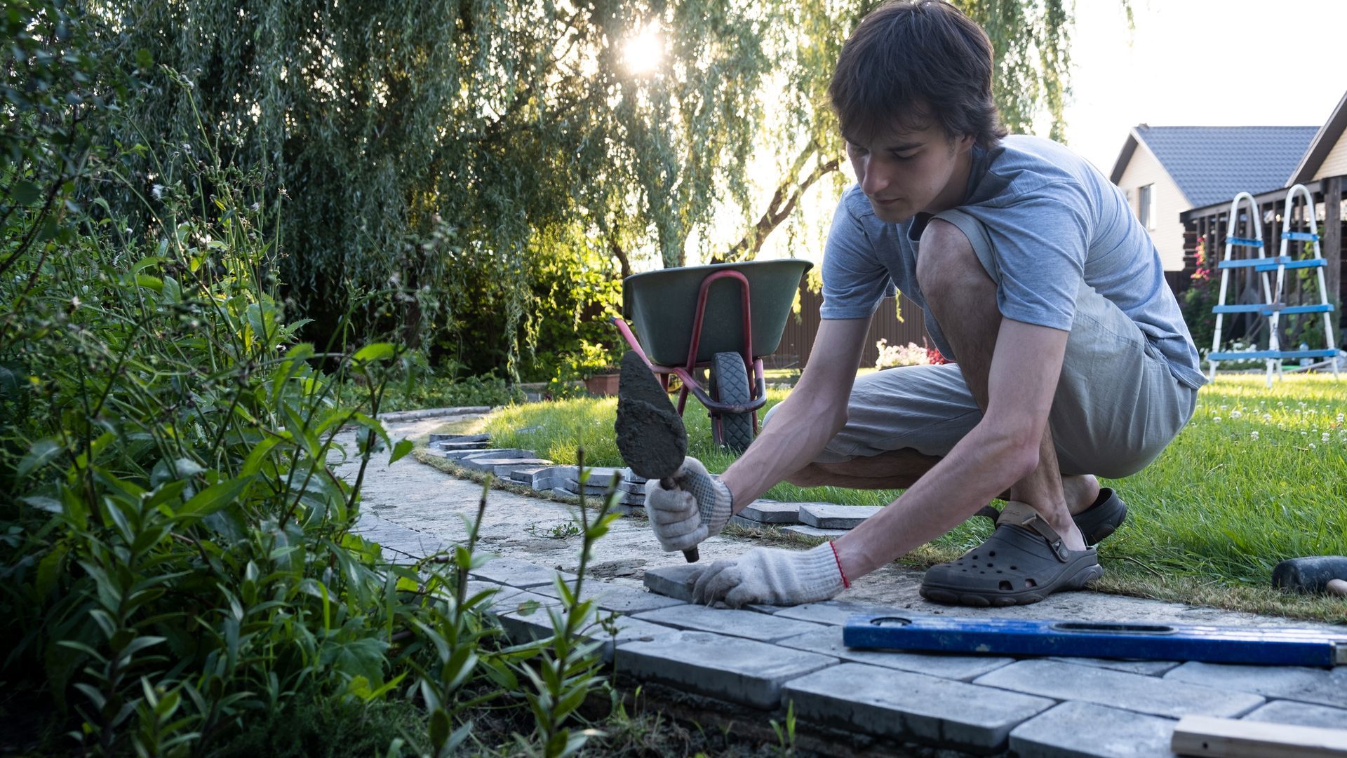 Self-laying of concrete paving slabs in the courtyard of the house.