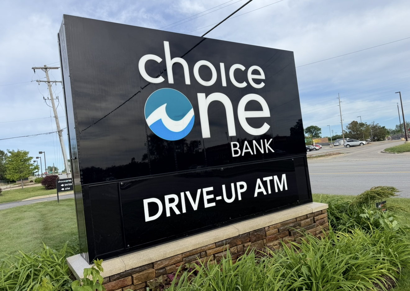 Choice One Bank sign with “Drive-Up ATM” on a roadside lawn