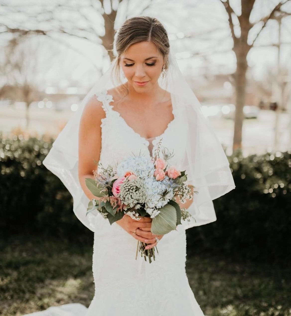 A bride in a white dress is holding a bouquet of flowers