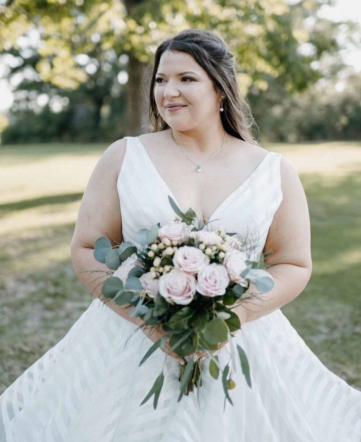 The bride is wearing a white dress and holding a bouquet of flowers.