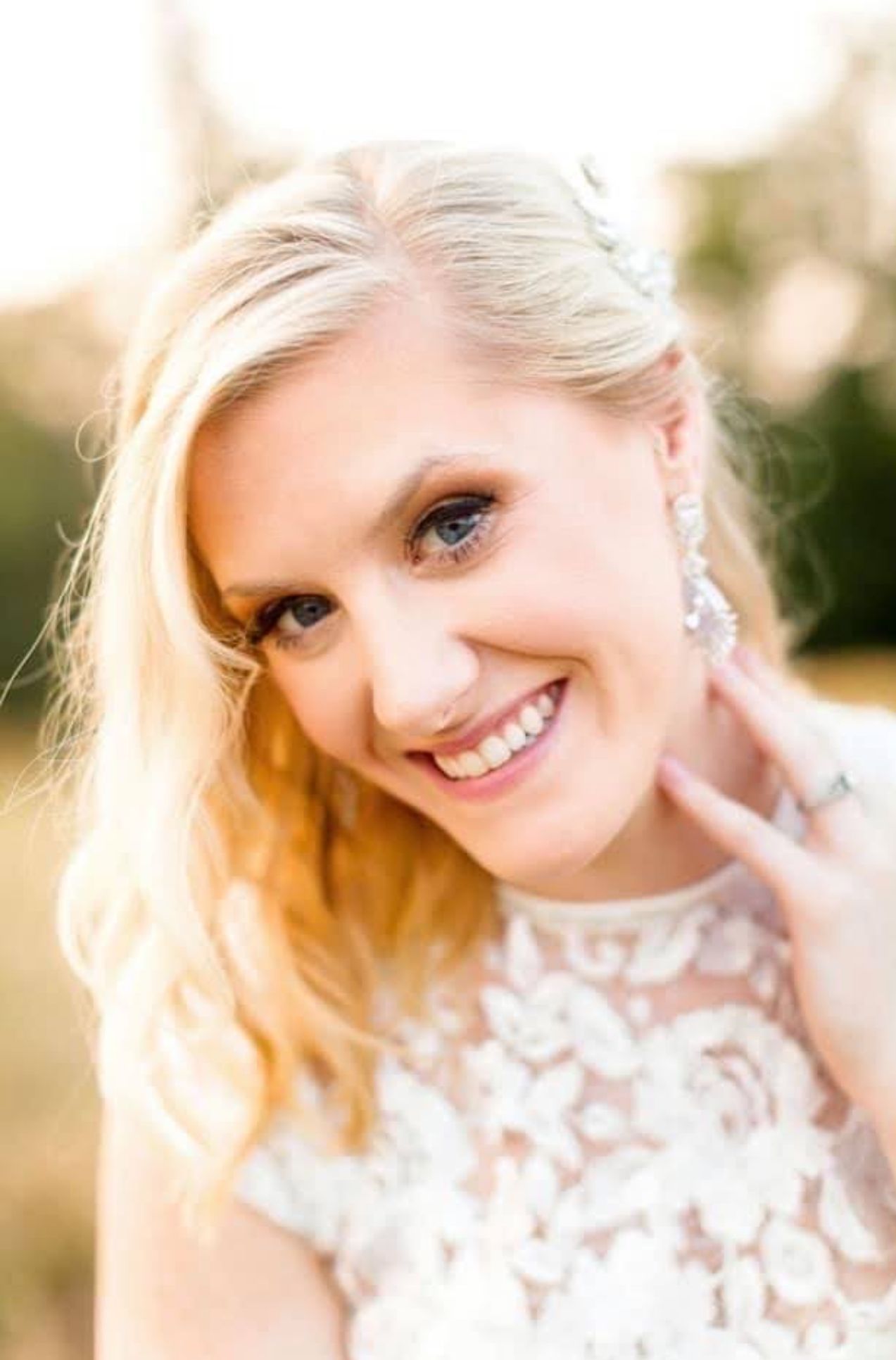 A close up of a woman in a white dress smiling.