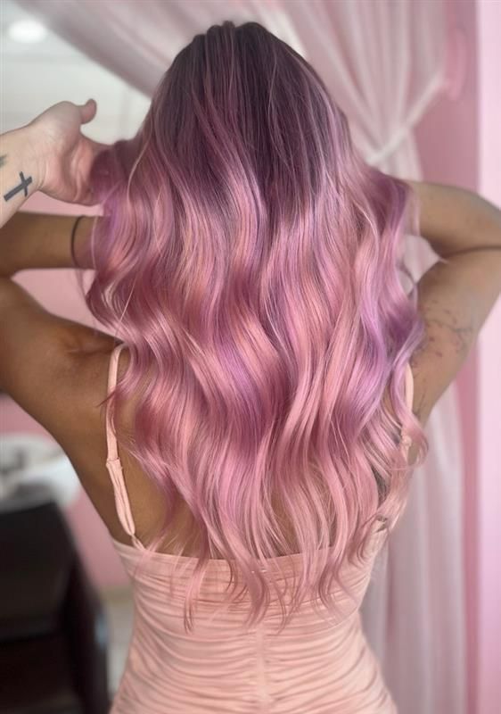 A person with long, wavy, pastel pink hair styled with a soft, multi-dimensional blend of lavender and soft pink hues.