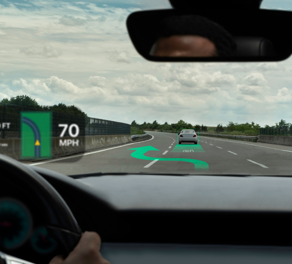 Driver’s view of a highway with a 70 mph sign and a car ahead under cloudy skies