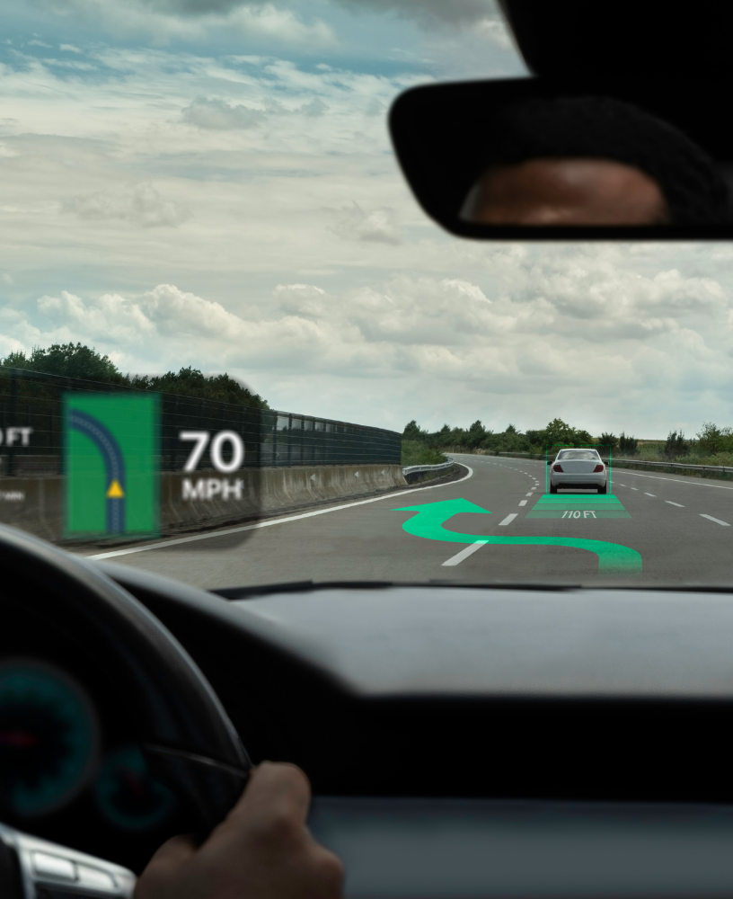 Driver’s view of a highway with a 70 mph sign and a car ahead under cloudy skies