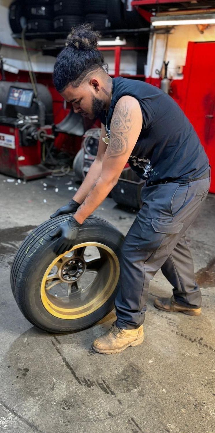A man is changing a tire in a garage.
