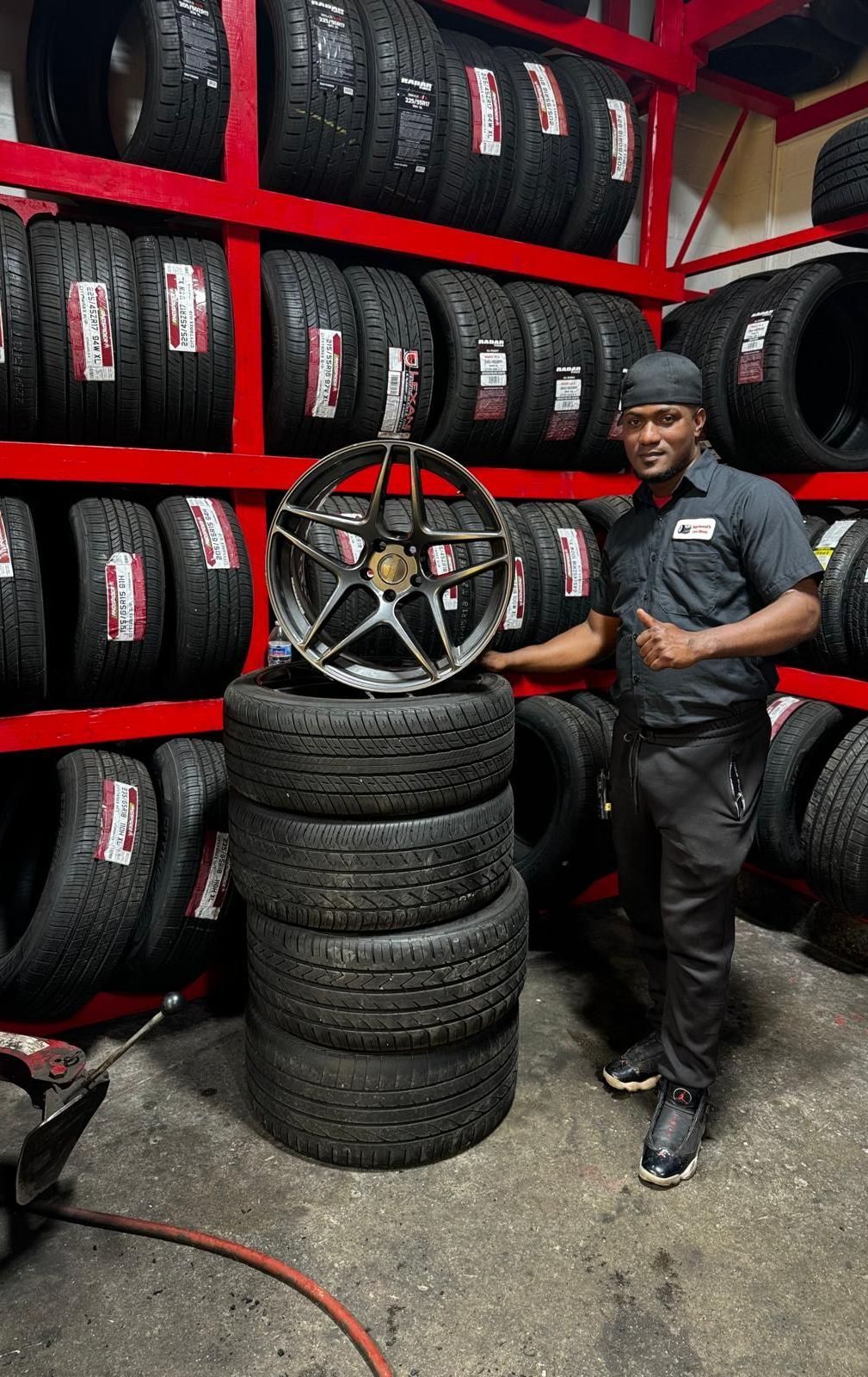 A man is changing a tire in a garage.