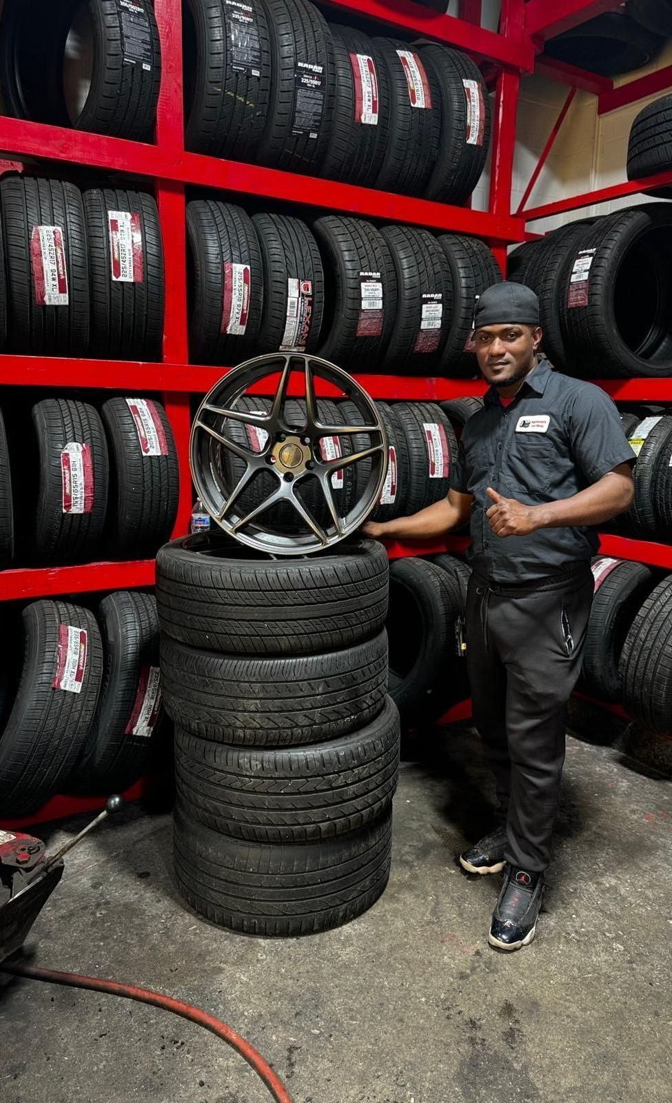 A man is changing a tire in a garage.