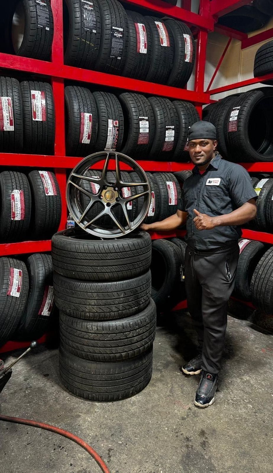 A man is changing a tire in a garage.