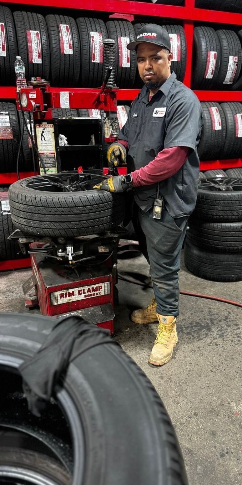 A man is working on a tire in a tire shop.