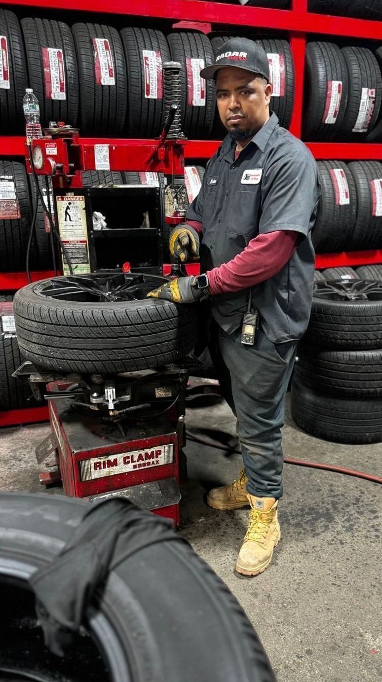 A man is working on a tire in a tire shop.