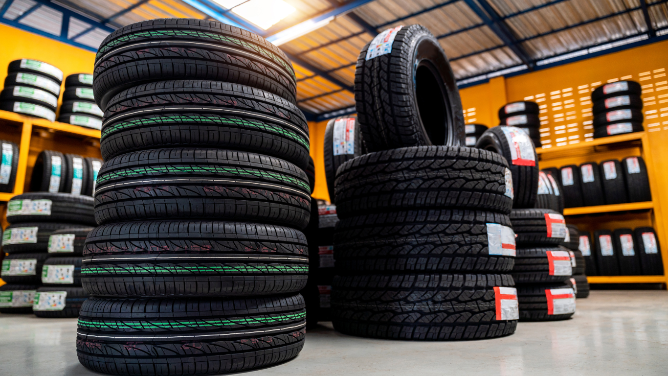 Stacks of new black tires in a tire shop, ready for sale.