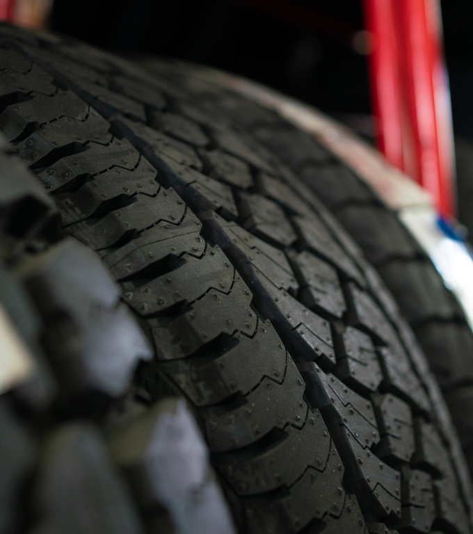Close-up of a stack of black car tires with deep treads.
