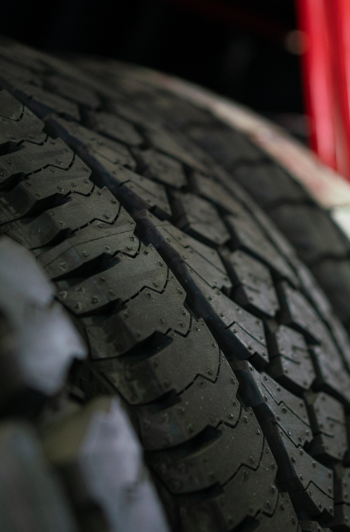 Close-up of a stack of black car tires with deep treads.