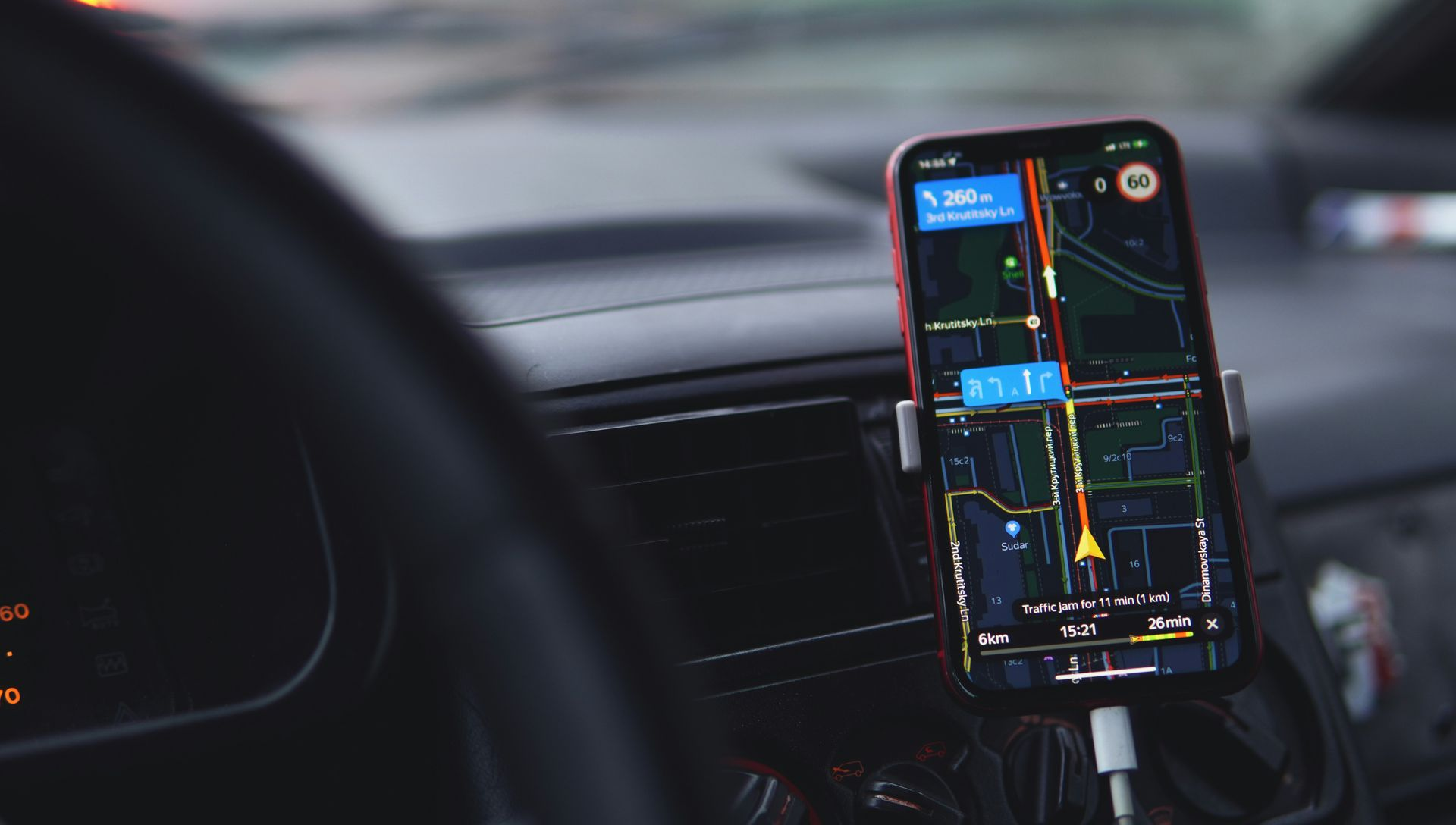 Car dashboard with a smartphone showing a navigation map mounted near the center console