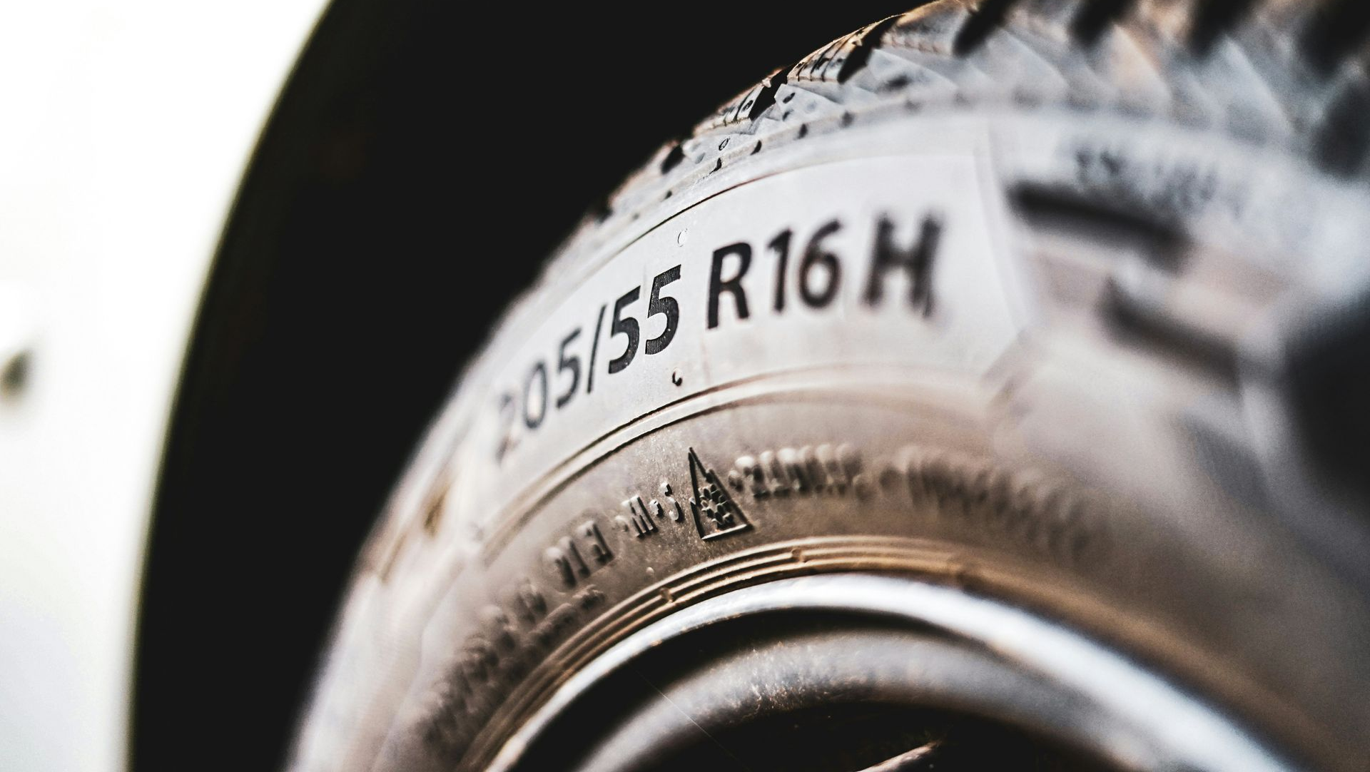 Close-up of a tire sidewall showing size markings on a vehicle wheel.