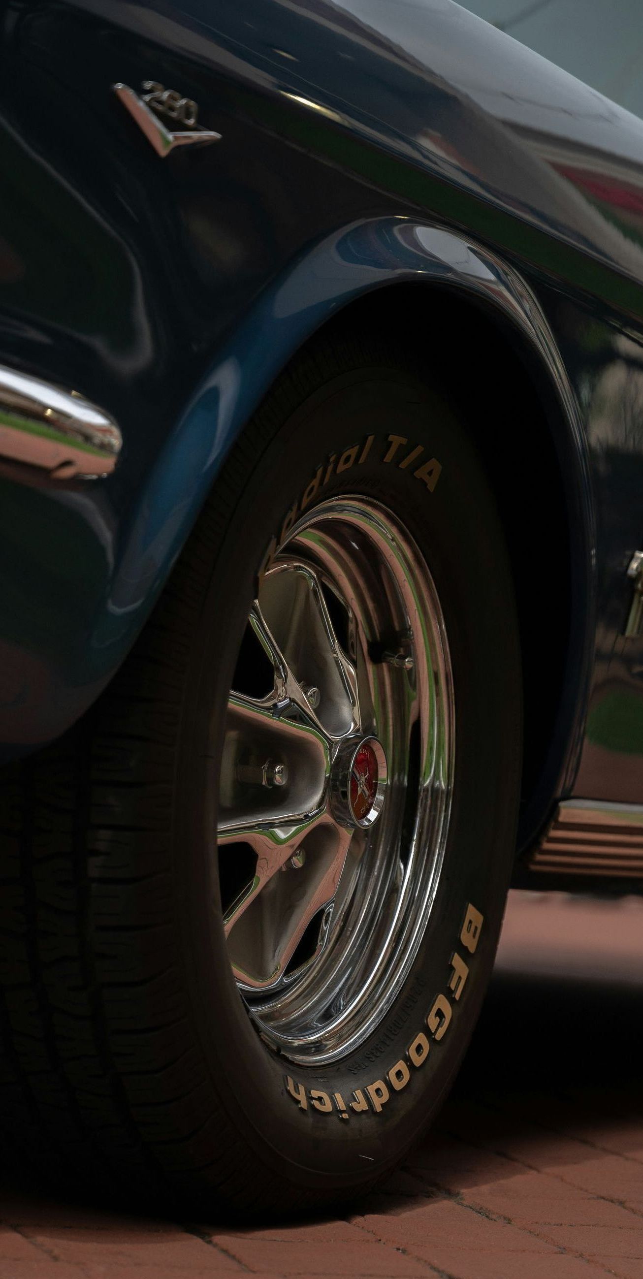 A close up of a car wheel on a brick road.