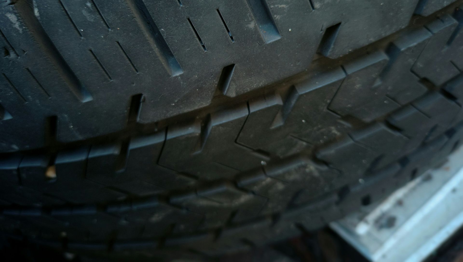 Close-up of a worn black tire with visible treads.