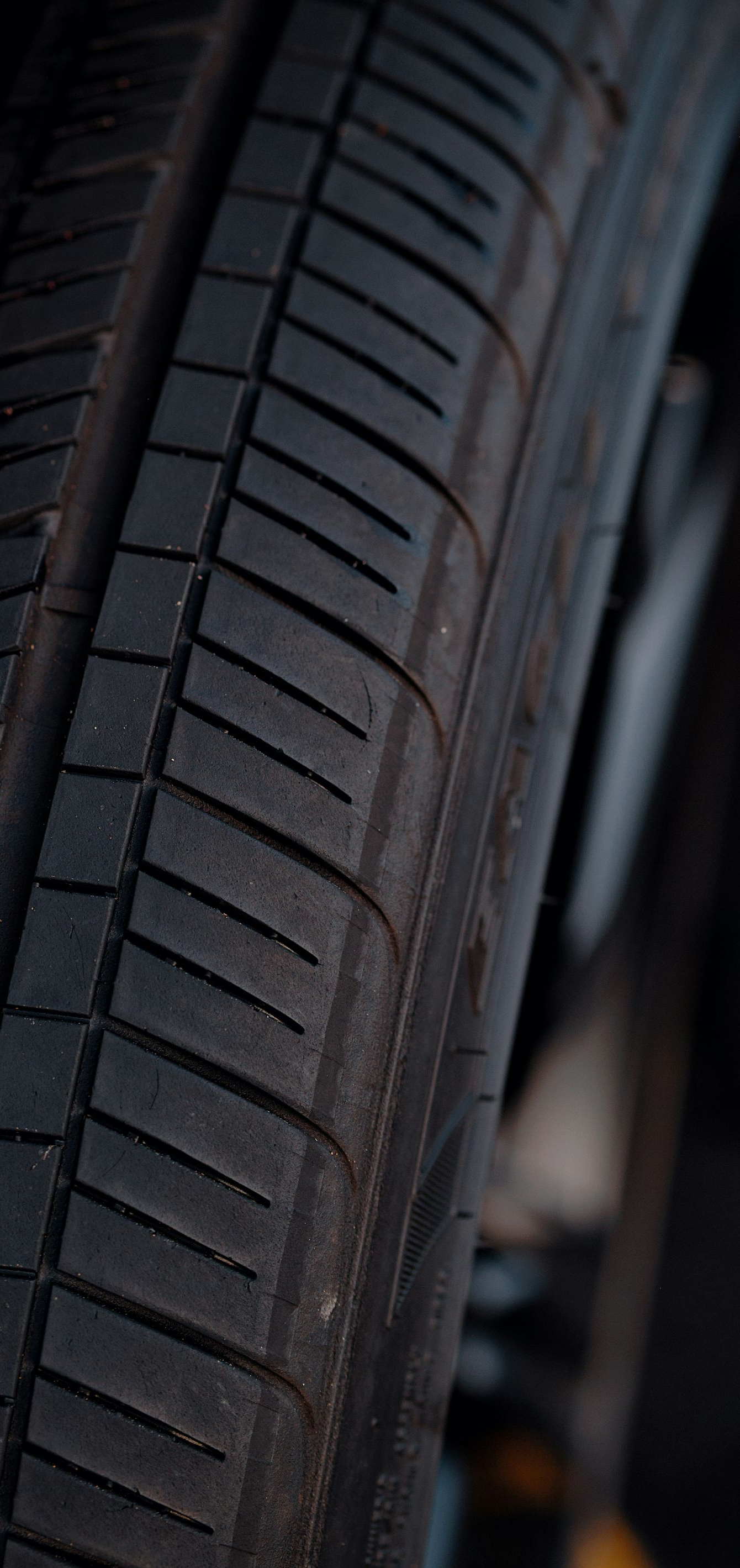Close-up of a car tire tread and sidewall in dim lighting